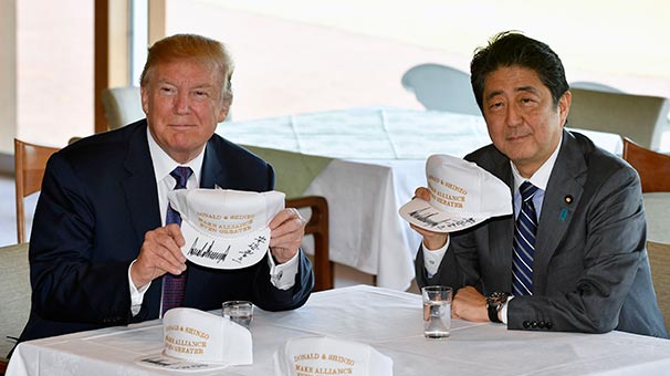 Trump ve Abe, “İttifakı daha da güçlendirin” yazılı birer şapka imzaladı.