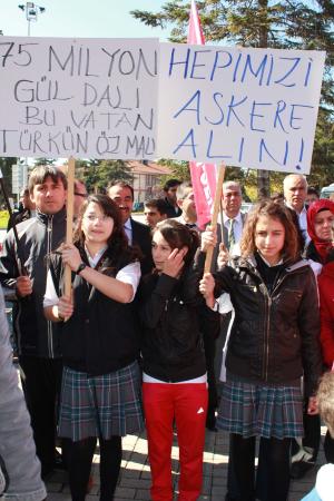 「私たちを兵役に」（左）とのプラカードを掲げる少女